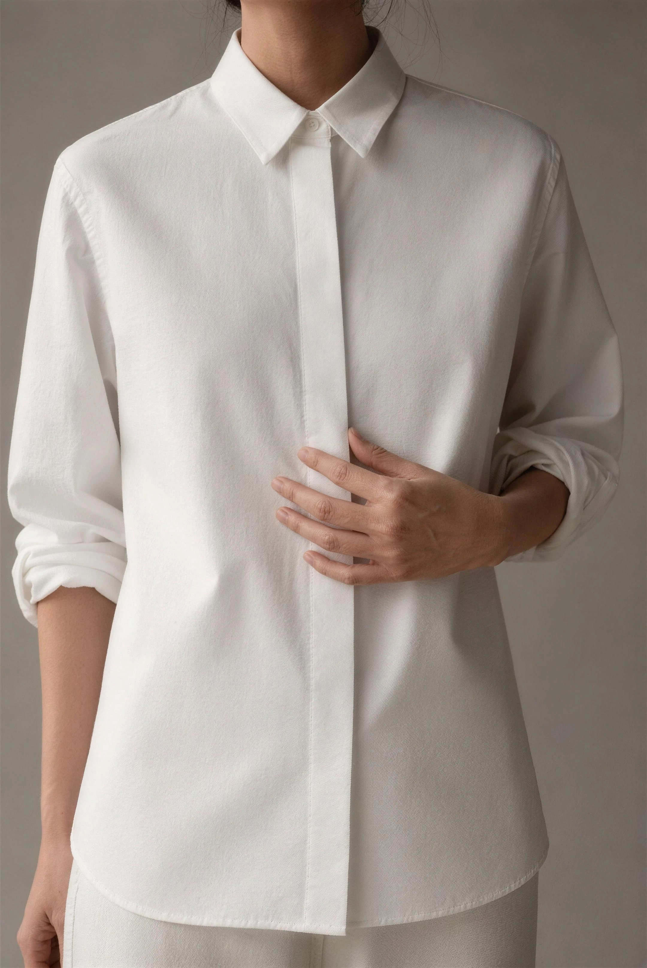 Chalk-white organic-cotton rue shirt with a covered placket, framed collarbone to hip